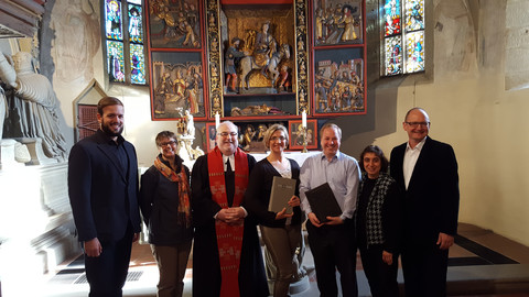 Ulrike Pitz (2. Vorsitzende des Kirchengemeinderats) präsentiert gemeinsam mit Pfarrer Volker Adler und weiteren Vertretern des Ev. Kirchengemeinderats Stöckenburg-Vellberg die neue Altarbibel.